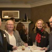 Four alumni smiling together at the event.